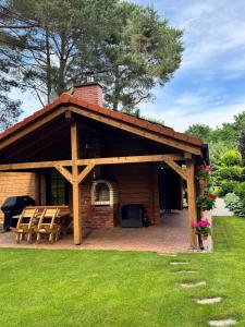 a wooden pavilion with a picnic table in a yard at Klimatyczny domek z drewna nad morzem in Debina