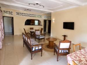 a living room with a table and chairs at Appartement Baie-Rose SP Nosy-Be in Nosy Be