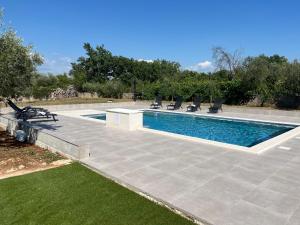a swimming pool with lounge chairs next to at Pax et Bonum in Lozovac