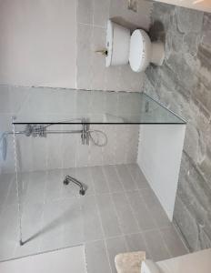 a bathroom with a glass shower stall with a sink at Farm Cottage in Athy