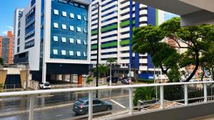 a car on a city street with tall buildings at Pousada Estrela Dourada in João Pessoa