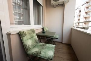 a chair and a table in a small room with a window at Dana in Požarevac