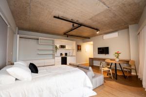 a bedroom with a large white bed and a table at Studio Piedade 45 | More do seu jeito in Belém +101 photos
