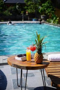a table with a pineapple and two glasses of orange juice at Tam Cốc AppA House in Ninh Binh