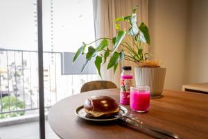 a table with a plate of pancakes and a pink drink at Studio Piedade 45 | More do seu jeito in Belém
