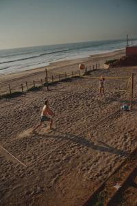 two people playing with a frisbee on the beach at Hotel Calma Celesti in Perihuete +24 photos