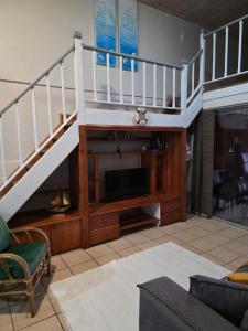 a living room with a staircase and a television at Unit 9 The Beachfront in Ramsgate