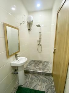 a bathroom with a sink and a mirror and a shower at Heritage Apartment in Ibadan +11 photos