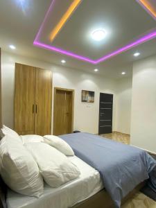 a bedroom with a large bed with a purple ceiling at Heritage Apartment in Ibadan