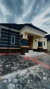 a blue and white house with a stone driveway at Heritage Apartment in Ibadan