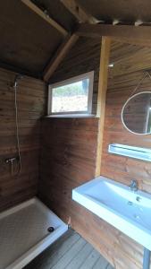 a bathroom with a tub and a sink and a window at La Roulotte Cacahuète in Pont-d'Ouilly