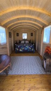 a bedroom with a bed in the middle of a room at La Roulotte Cacahuète in Pont-d'Ouilly +3 photos