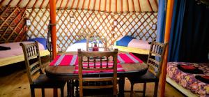 a table in a yurt with two bunk beds at Le portillon des fées in Sost