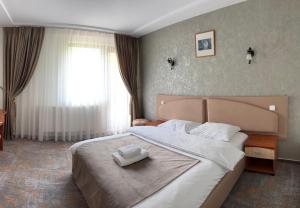 a bedroom with a large bed with two towels on it at Rotonde View in Predeal