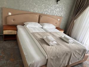 a bedroom with a bed with two towels on it at Rotonde View in Predeal +4 photos