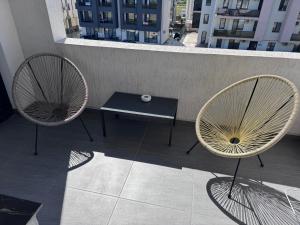 two chairs and a table on a balcony at Cozy Crib 2 in Mamaia Sat/Năvodari