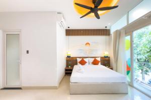 a bedroom with a bed and a ceiling fan at Dorm Beachside Hotel & Hostel By Haviland in Danang +42 photos