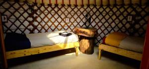 a room with two beds and a table in a yurt at Le portillon des fées in Sost +14 photos