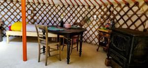 a room with a table and chairs in a yurt at Le portillon des fées in Sost