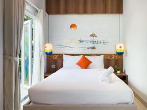 a bedroom with a white bed and a window at Dorm Beachside Hotel & Hostel By Haviland in Danang