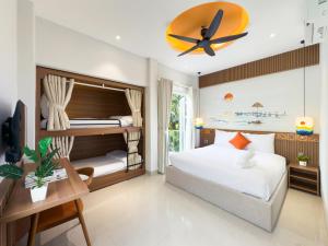 a bedroom with bunk beds and a ceiling fan at Dorm Beachside Hotel & Hostel By Haviland in Danang