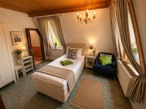 a bedroom with a bed and a chair and window at Pension & Restaurant Zu den Linden Radebeul in Radebeul +41 photos