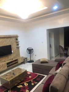 a living room with a couch and a tv at House 22 Apartments in Kubwa +8 photos