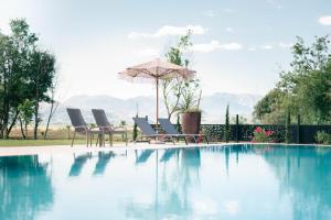 a group of chairs and an umbrella next to a swimming pool at Salinas Nest - Ulcinj Stoj Ada Bojana in Ulcinj