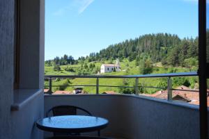 a balcony with two tables and a view of a mountain at Къща за гости Мекана in Borino