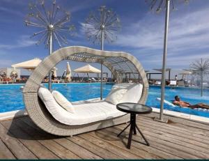 a wicker rattan swing chair next to a pool at Марсельская Residence in Kryzhanivka