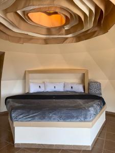 a bedroom with a bed with a wooden ceiling at Glamping Cabañas Luz y Vida in Chignahuapan
