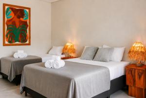 two beds in a hotel room with towels on them at Luau Hotel in Flecheiras +28 photos