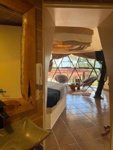 a room with a bed and a bathroom with a tub at Glamping Cabañas Luz y Vida in Chignahuapan