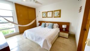 a white bedroom with a bed with blue pillows at Magico Apartamento Frente al Mar 3 Habitaciones TR72 in Guayabal +54 photos