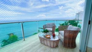 a balcony with chairs and a table and the ocean at Magico Apartamento Frente al Mar 3 Habitaciones TR72 in Guayabal