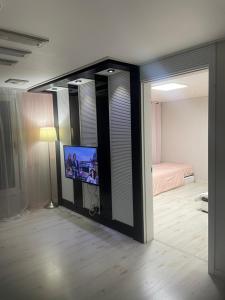 a room with a tv and a bedroom with a bed at 외국인여성전용게스트하우스 in Pup'yŏng-yŏk