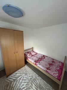 a small bedroom with a bed and a cabinet at Cottage near Ostrog in Gornja Povija