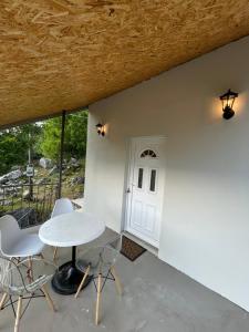 a patio with a table and chairs and a door at Cottage near Ostrog in Gornja Povija