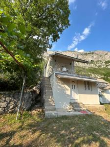 a small house with stairs leading up to it at Cottage near Ostrog in Gornja Povija