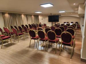 ein Konferenzraum mit Stühlen und einer Projektionsfläche in der Unterkunft Hotel Iliana in Filippiada