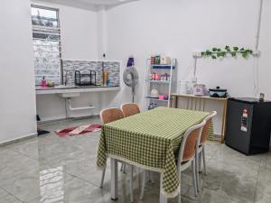 a table and chairs in a kitchen with a table and a table and a counter at Tetiba Suite in Muar