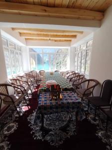 a large room with a long table and chairs at Nofin Lake House in Panjakent