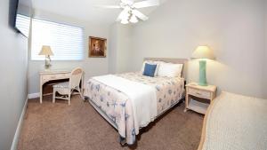 a bedroom with a bed and a desk and a window at 207 Mariners Club in Key Largo +47 photos