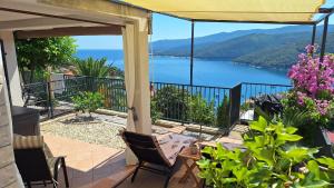 a balcony with a view of a body of water at Studio Apartment Đuli Rabac with private hot tub, bike box and free parking in Rabac