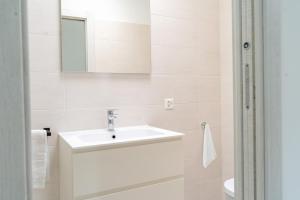 a white bathroom with a sink and a mirror at Villa Sementina - Luxury Stay with Pool and Gym - 15 m to Lake Maggiore in Bellinzona