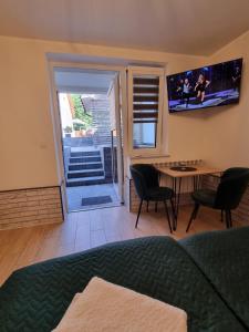a living room with a table and chairs and a television at Biały Port in Rajgród