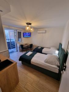 a bedroom with a bed and a table and a television at Biały Port in Rajgród