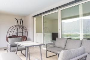 a living room with a couch and chairs and a table at Villa Sementina - Luxury Stay with Pool and Gym - 15 m to Lake Maggiore in Bellinzona