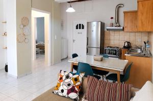 a kitchen with a table and a refrigerator at Stone Family Home Garden Center Beach in Kyparissia