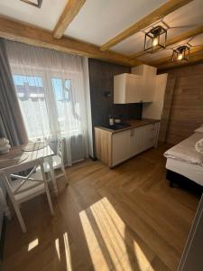 a bedroom with a table and a bed and a kitchen at Dom przy Wangu Karpacz in Karpacz